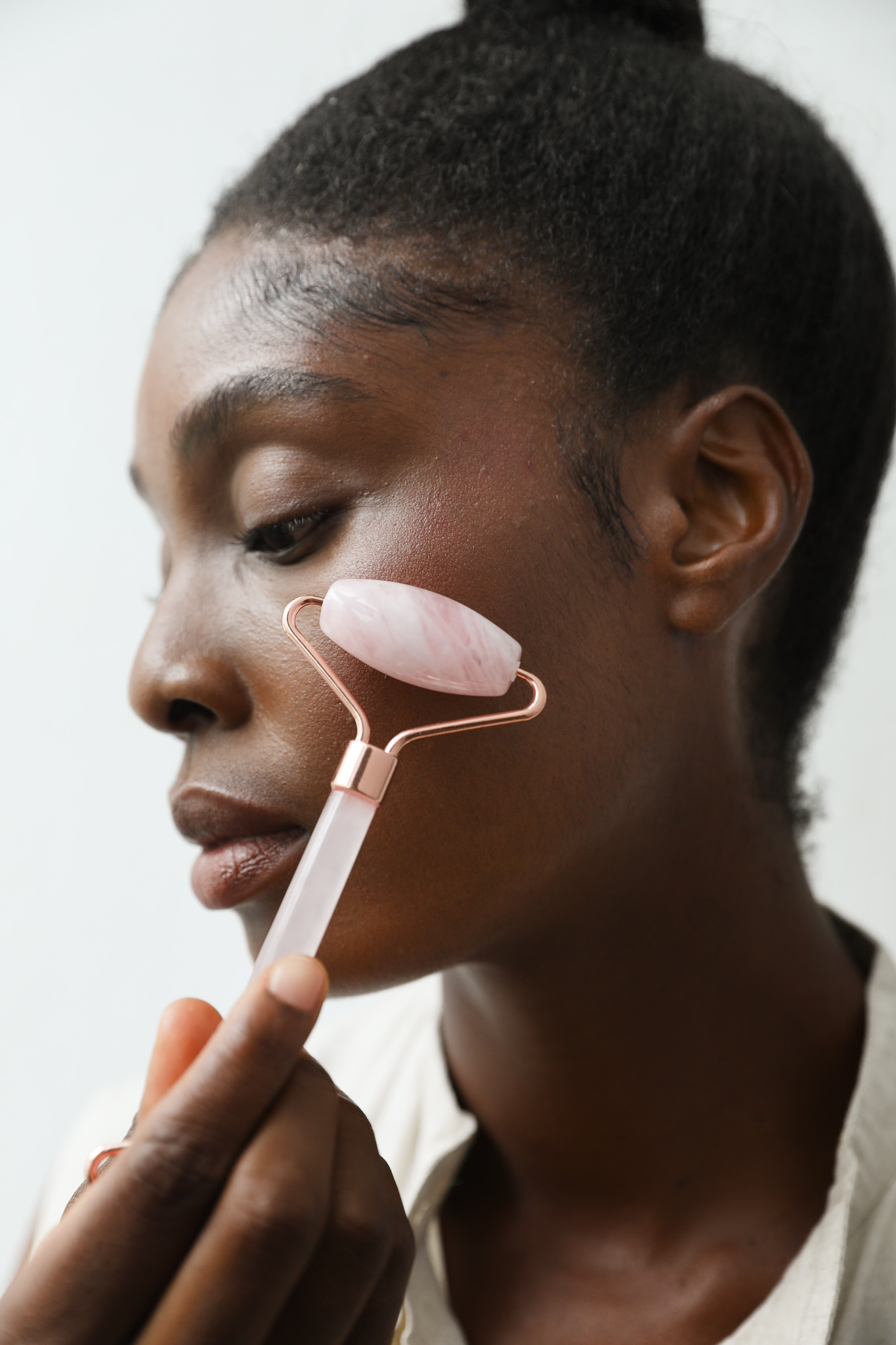 A rose quartz facial roller, used for lymphatic drainage and helping skincare penetration