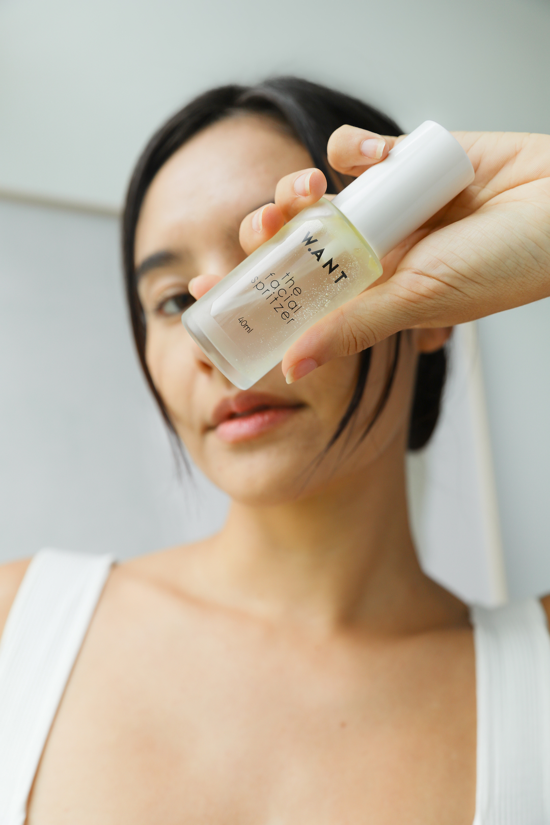 Women holding up a natural face toner by Singapore-based brand WANT Skincare, available on ZERRIN